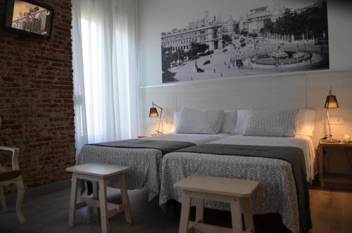 a bedroom with a large bed with two tables at Hostal San Lorenzo in Madrid