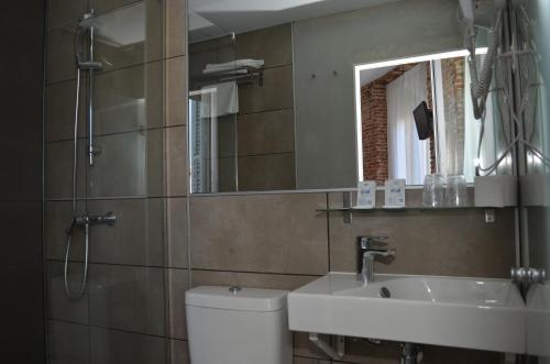 a bathroom with a sink and a toilet and a mirror at Hostal San Lorenzo in Madrid