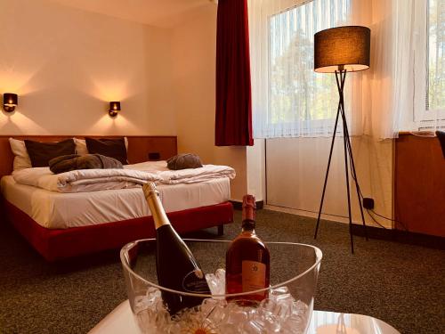Habitación de hotel con 1 cama y 2 botellas de vino en Hotel Motodrom, en Hockenheim