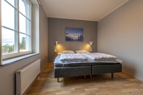 a bedroom with a bed in a room with two windows at Kläppen Ski Resort in Transtrand