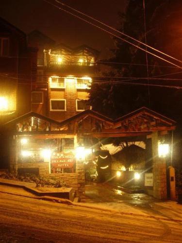 a house with lights in front of it at night at Ruca Cheli Village Ski Hotel in San Carlos de Bariloche