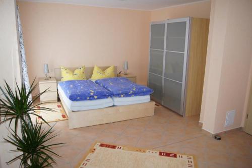 1 dormitorio con 1 cama con sábanas azules y almohadas amarillas en Ferienwohnungen Buchholz, en Büsum