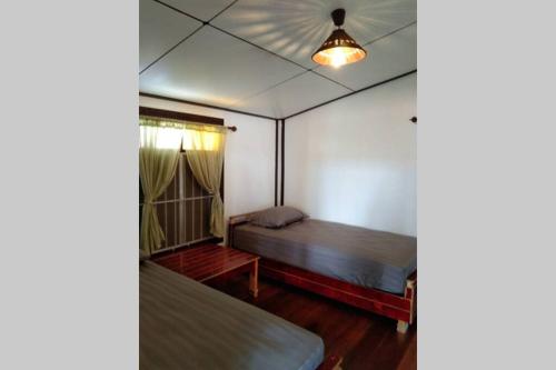 a bedroom with two beds and a light on the ceiling at Ocean front 2br 107sqm house - Panorama Sea View in Laem Ngop