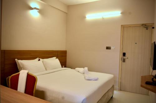 una camera d'albergo con un letto e un asciugamano sopra di The First Light Inn a Kanchipuram