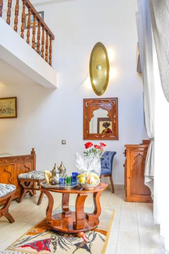 a living room with a table and a staircase at Villa Quieta in Essaouira