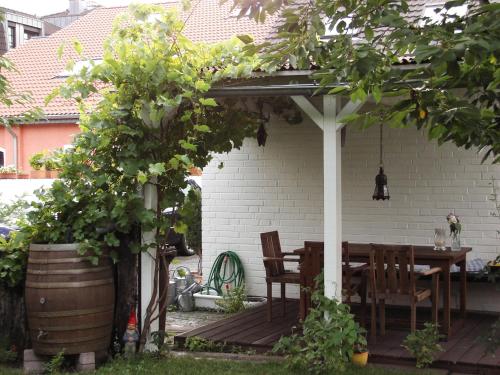 a wooden table and chairs under a pergola at Haus Rothenstein, ruhige FeWo, ca. 10 min. zu Messe und Flughafen in Meerbusch