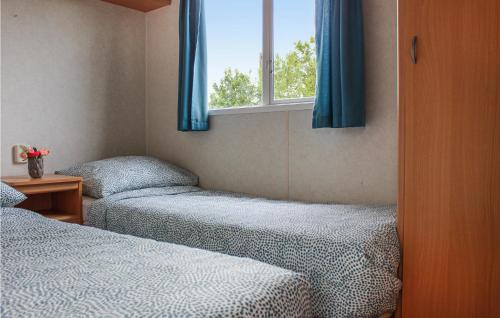 een slaapkamer met 2 bedden en een raam met blauwe gordijnen bij Huis Nr, 5 in Woubrugge