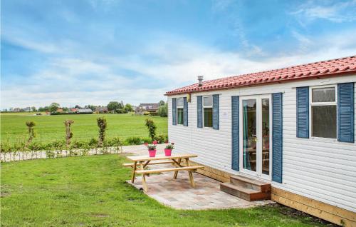 a small white cottage with a picnic table in the yard at Huis Nr 5 in Woubrugge