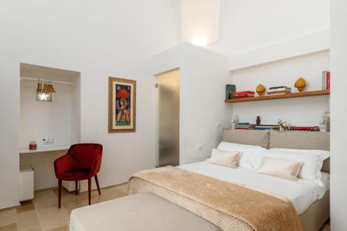 a bedroom with a bed and a red chair at Masseria Limonaia & Spa in Fasano