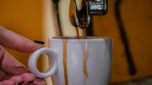 a person is pouring coffee into a coffee cup at Hotel Bankya Palace in Bankya