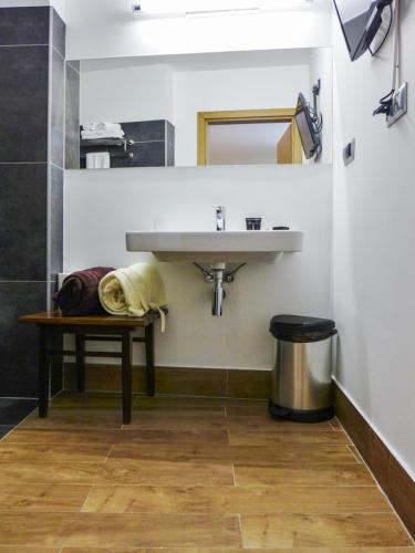a bathroom with a sink and a bench under it at Aroma Stone Hotel Spa in Syców