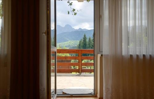 - Puerta a un balcón con vistas a las montañas en udanypobyt Apartament Myśliwski, en Kościelisko