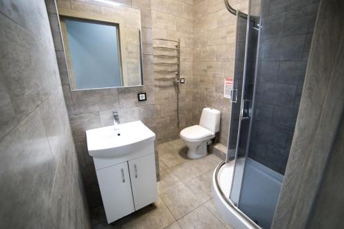 a bathroom with a toilet and a sink and a shower at Lviv4U in Lviv