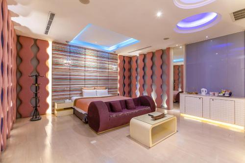 a bedroom with a bed and a couch in a room at Vogue Boutique Motel in Yangmei