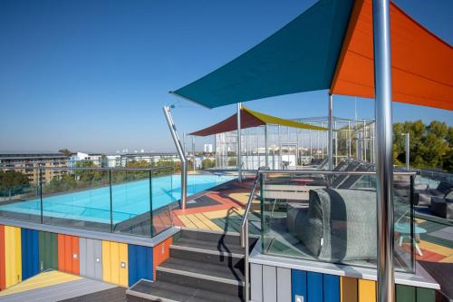 a swimming pool with an umbrella and stairs next to it at The Brucklyn Apartments in Erlangen