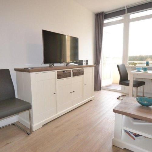 a living room with a flat screen tv on a cabinet at Appartement-44 in Westerland