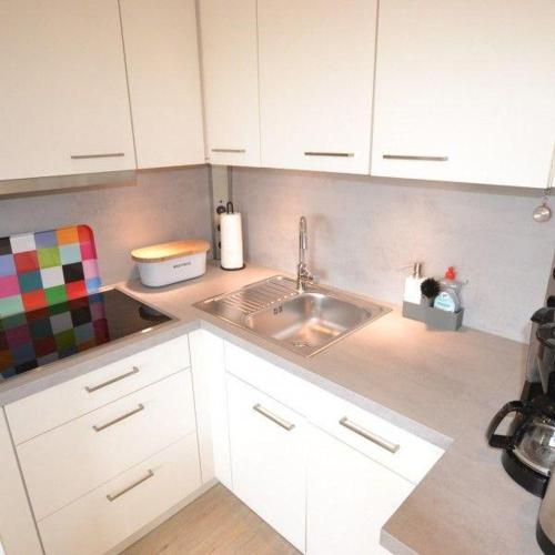 a kitchen with white cabinets and a sink at Appartement-44 in Westerland (Sylt)
