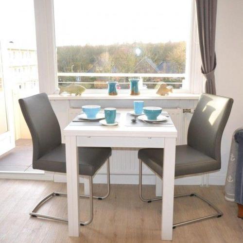 a white table with two chairs and a window at Appartement-44 in Westerland