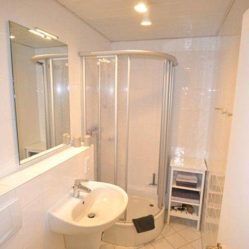 a white bathroom with a sink and a shower at Appartement-44 in Westerland (Sylt)