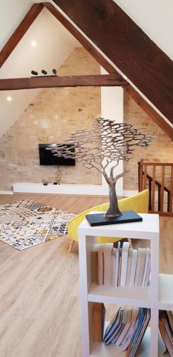 a living room with a tree mural on the wall at Le gîte de la Vieille Eglise de Coussergues in Coussergues