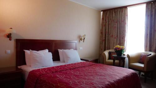 a hotel room with a bed with a red bedspread at Hotel Bankya Palace in Bankya