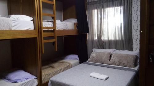 
a bedroom with a bunk bed and a desk at Pousada e Hostel do PIO in Canela
