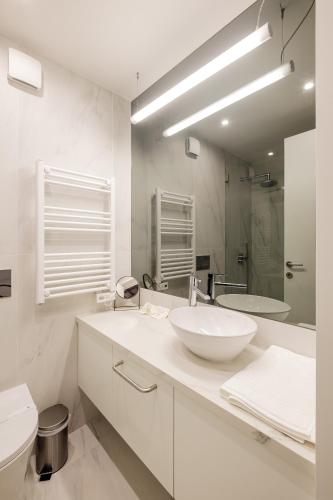 a white bathroom with a sink and a mirror at BOUTIQUE Rentals- ATTICO Luxury Design-Ocean views in Porto