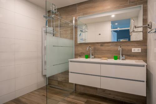 ein Bad mit einem Waschbecken und einem Spiegel in der Unterkunft Appartementencomplex Juliana 116 in De Koog