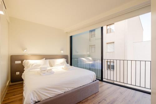 sypialnia z łóżkiem i dużym oknem w obiekcie BOUTIQUE Rentals- ATTICO Luxury Design-Ocean views w Porto