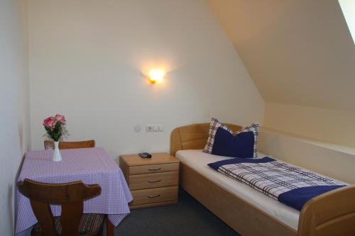 Dormitorio pequeño con cama y mesa en Schwarzer Adler, en Schwaighausen