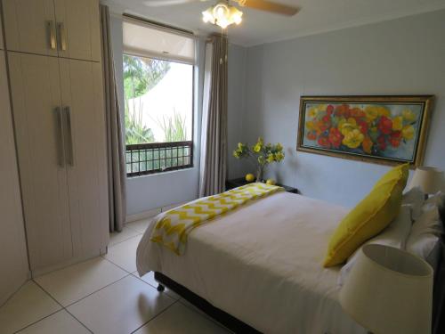um quarto com uma cama grande e uma janela em 130 BREAKERS RESORT HOTEL Umhlanga em Durban