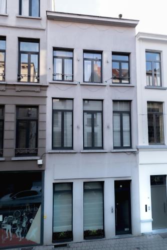 a white building with many windows on a street at Klapdorp in Antwerp