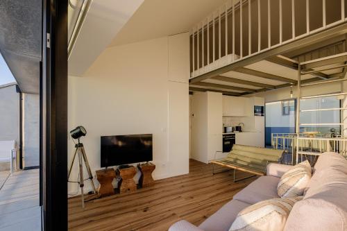 sala de estar con sofá y TV en BOUTIQUE Rentals- ATTICO Luxury Design-Ocean views, en Oporto