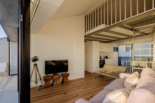 a living room with a couch and a television at BOUTIQUE Rentals- ATTICO Luxury Design-Ocean views in Porto
