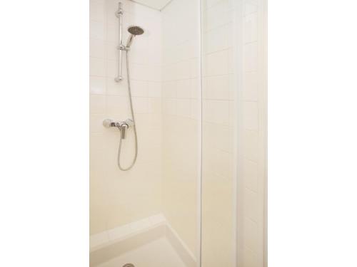 een douche met een douchekop in de badkamer bij ibis budget Tours Centre Gare et congrès in Tours