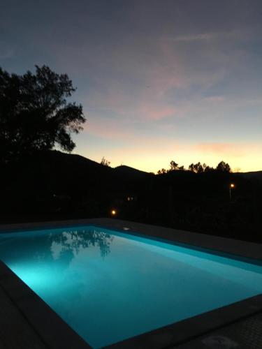 a swimming pool with a sunset in the background at Casa Da Calçada in Castelo de Paiva