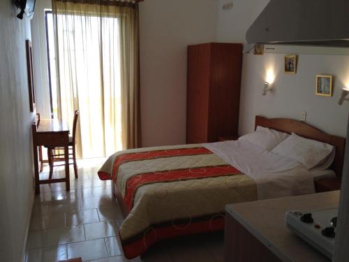 a hotel room with a bed and a table and a desk at Zefyros Studios in Damnoni