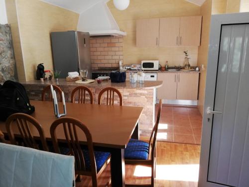 a kitchen with a wooden table with chairs and a counter top at Casa Da Calçada in Castelo de Paiva