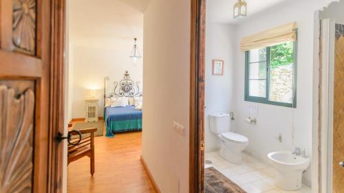 a bathroom with a toilet and a bedroom with a bed at Casa Piedras Gaucin by Ruralidays in Gaucín