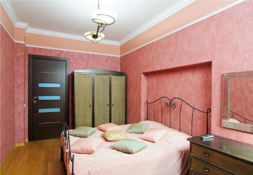 a pink bedroom with a bed and a dresser at Kvartira Gorodskoy Val 10 in Minsk