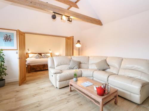 a living room with a white couch and a bed at The Duck House in Thetford