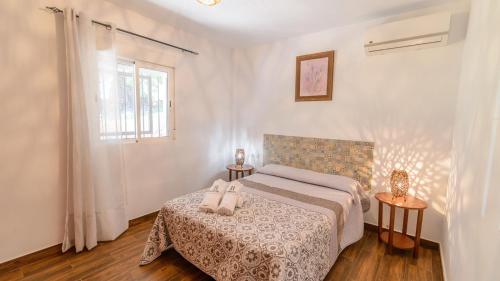 Un dormitorio con una cama con dos zapatos. en Casa Encina Tolox by Ruralidays, en Tolox