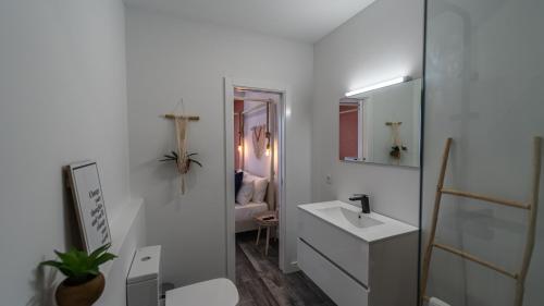 a white bathroom with a sink and a mirror at Plan Be GuestHouse in Faro