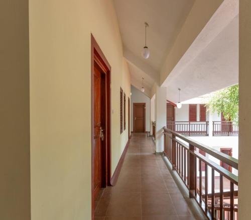an empty hallway with a door and a balcony at KSTDC Hotel Mayura Yagachi, Belur in Belūr