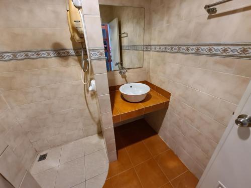 a small bathroom with a sink and a shower at Phutawan Resort in Chai Badan