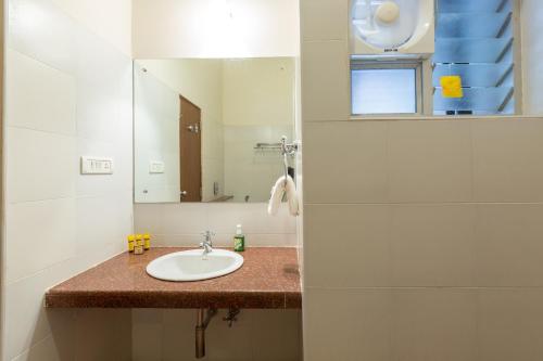 a bathroom with a sink and a mirror at KSTDC Hotel Mayura Yagachi, Belur in Belūr