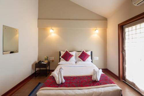 een slaapkamer met een groot bed en een rode deken bij KSTDC Hotel Mayura Yagachi, Belur in Belūr