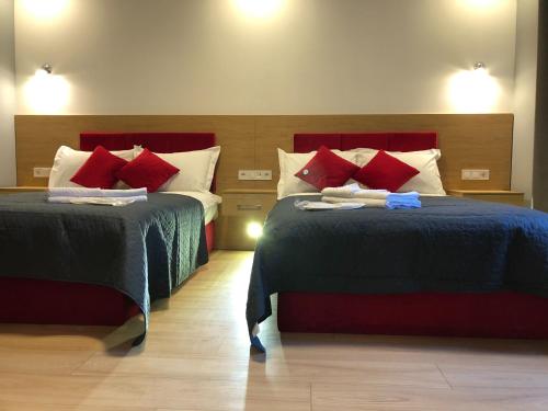 a hotel room with two beds with red pillows at Partner Guest House in Kyiv
