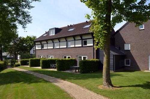 a building with a tree in front of it at Buitenplaats De Mechelerhof in Mechelen