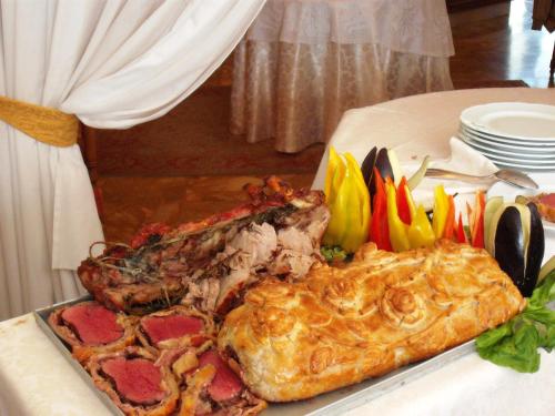 a plate of food with meat and vegetables on a table at Hotel Olympic in Saint Vincent